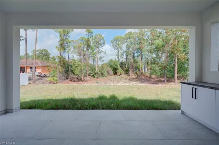 View of green lawn featuring a patio