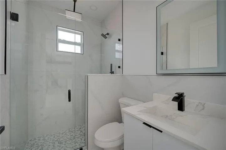Full bathroom with vanity and a marble finish shower