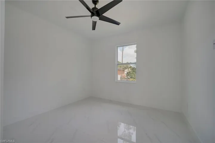 Empty room with light marble finish flooring and ceiling fan