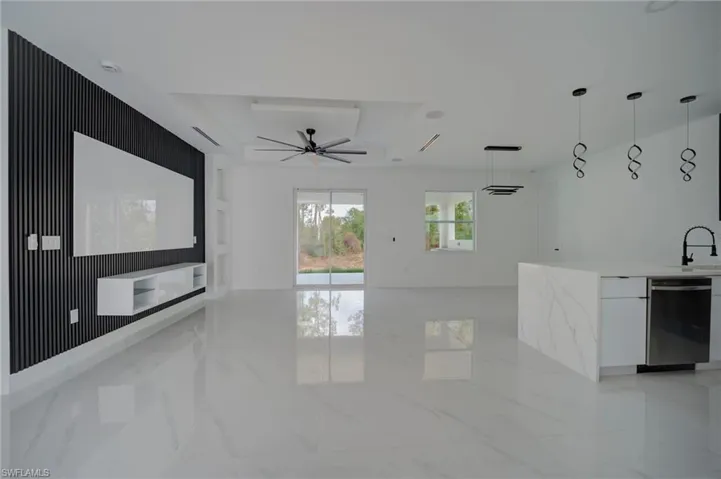 Unfurnished living room with a ceiling fan and a sink