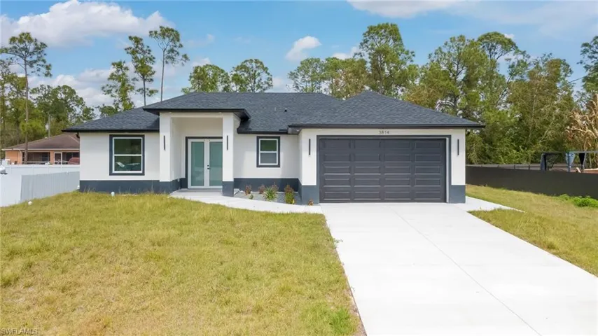 View of front of home with french doors, an attached garage, concrete driveway, stucco siding, and roof with shingles