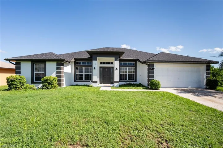 Front of house with a two-car garage and front lawn