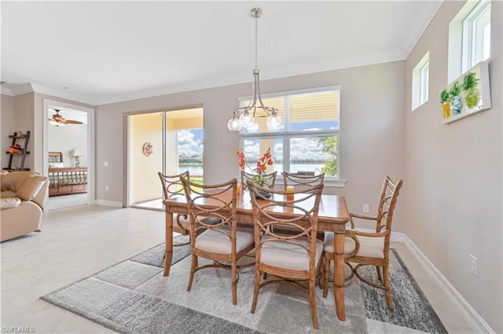 Dining space featuring crown molding, healthy amount of natural light, light tile patterned flooring, and ceiling fan