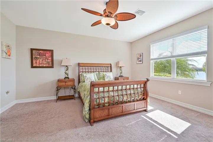 Bedroom with light colored carpet and ceiling fan