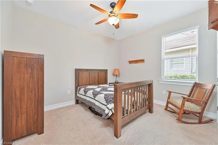Bedroom with light colored carpet and a ceiling fan