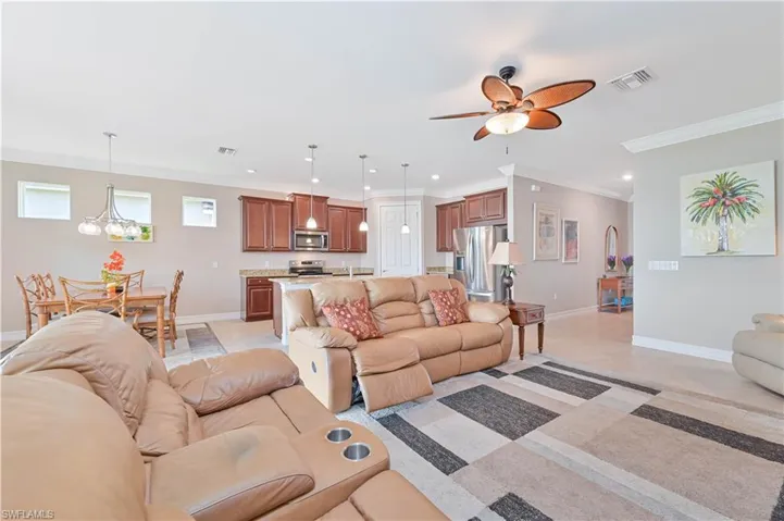 Living area with crown molding, a chandelier, ceiling fan, and recessed lighting