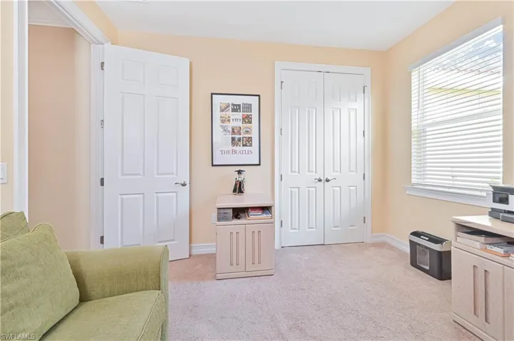 Living area with light colored carpet and baseboards