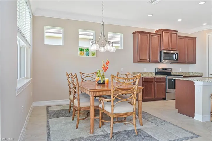 Dining space with ornamental molding, a chandelier, light tile patterned floors, and recessed lighting