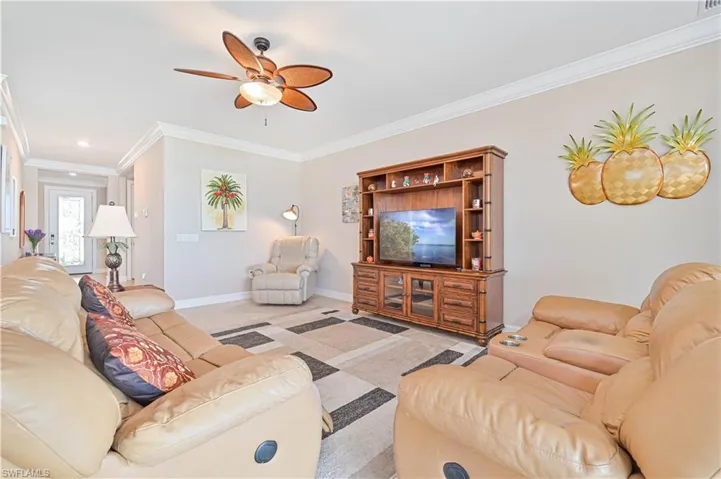 Living area with crown molding and ceiling fan