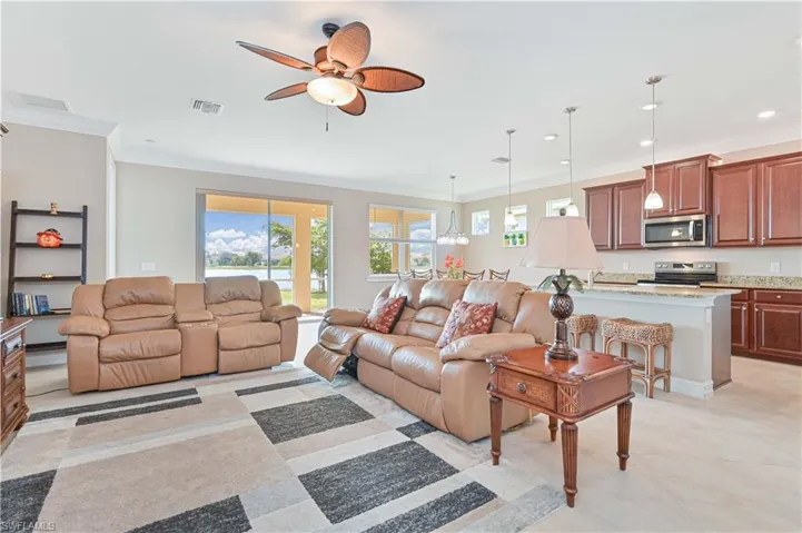 Living area with crown molding, ceiling fan, and recessed lighting