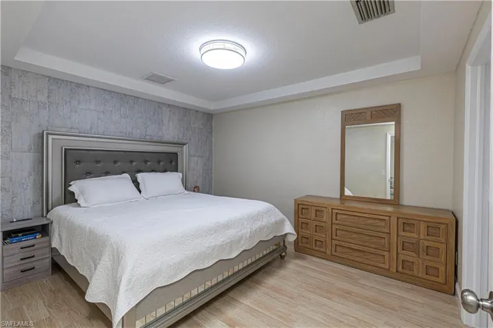 Bedroom featuring light wood-style flooring and a raised ceiling