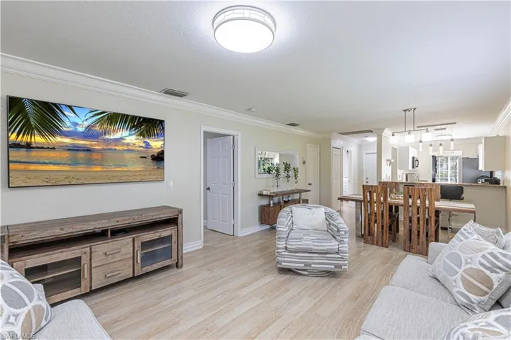 Living area featuring ornamental molding and light wood finished floors