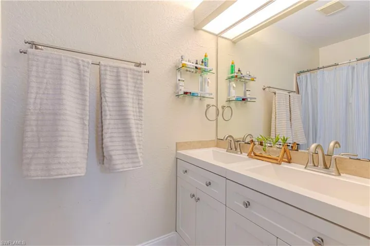 Bathroom featuring double vanity and a shower with shower curtain