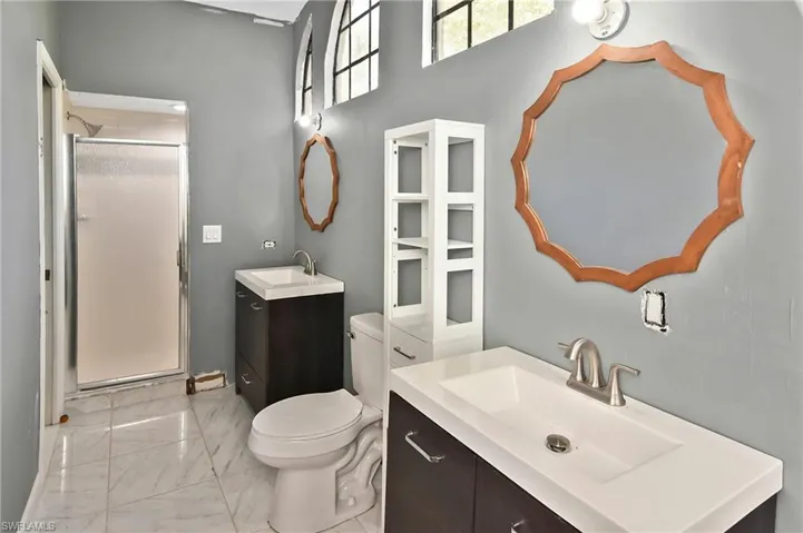Full bathroom with vanity, a stall shower, and light marble finish flooring