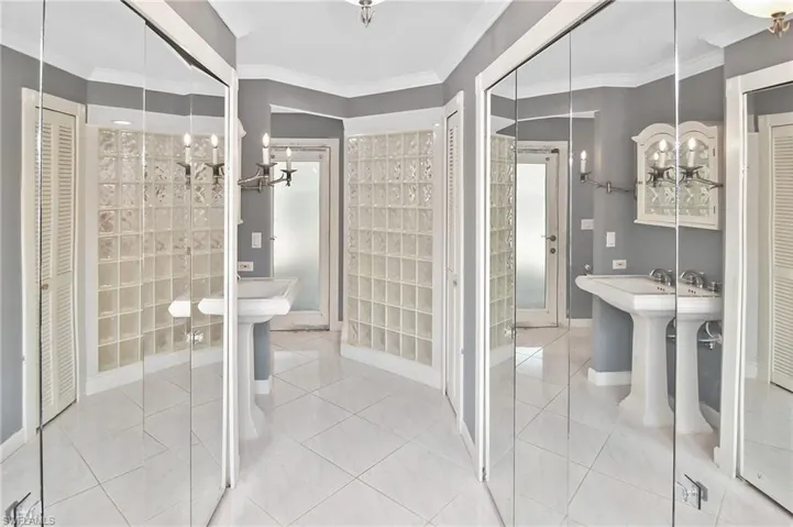 Full bath with a closet, hanging lights, crown molding, and light tile patterned floors