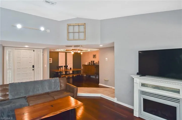 Living room with dark wood-style flooring and vaulted ceiling
