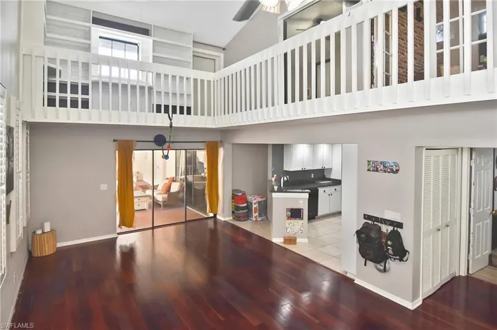 Living room featuring light wood finished floors, a high ceiling, and ceiling fan