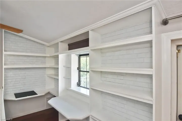 Walk in closet with lofted ceiling and dark wood-type flooring