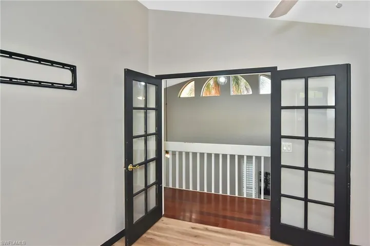 Doorway to outside with wood finished floors, ceiling fan, and french doors