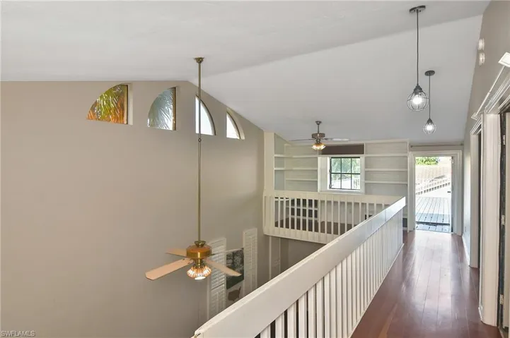 Hall featuring lofted ceiling and dark wood-type flooring