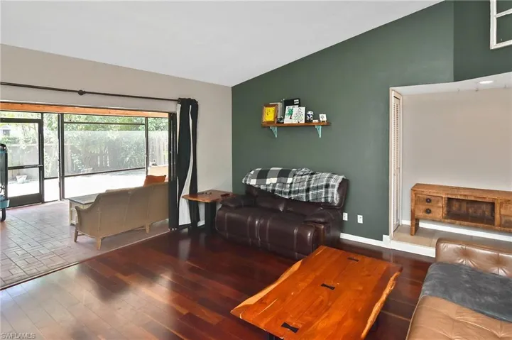 Living area with vaulted ceiling and wood finished floors