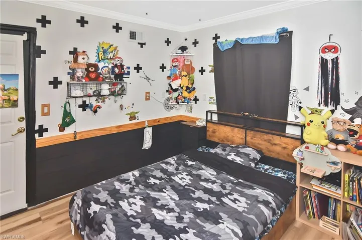 Bedroom with ornamental molding and light wood-type flooring
