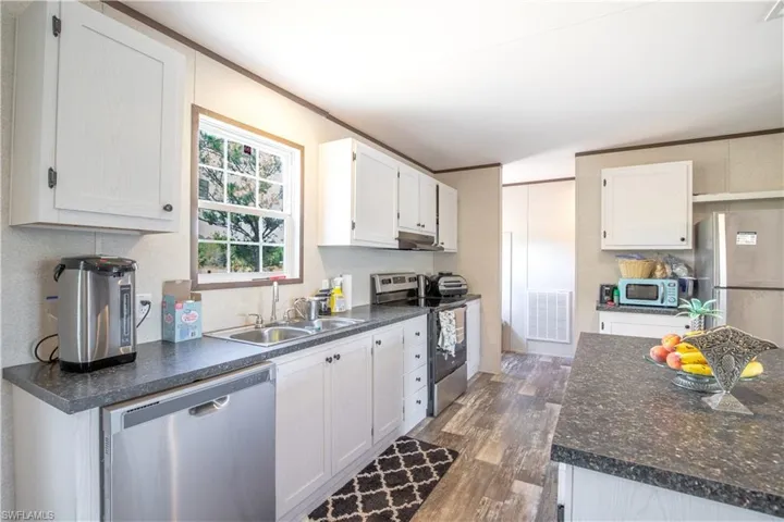 Kitchen with white cabinetry, appliances with stainless steel finishes