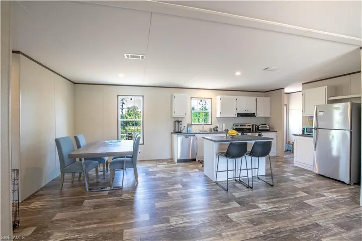 Kitchen with a center island, stainless steel appliances, white cabinets,