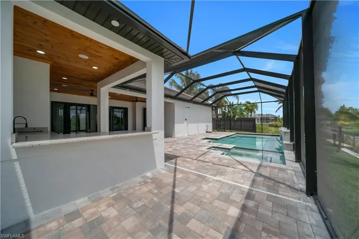 View of swimming pool with a patio area, a sunroom, a lanai, and a pool with connected hot tub