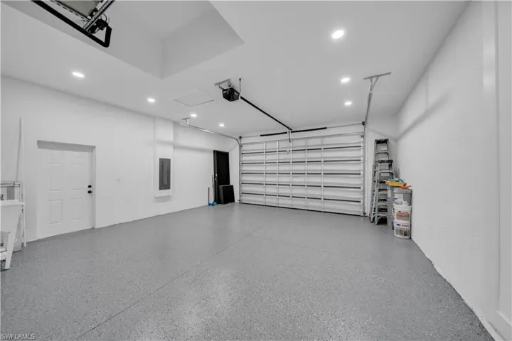 Garage featuring recessed lighting and electric panel