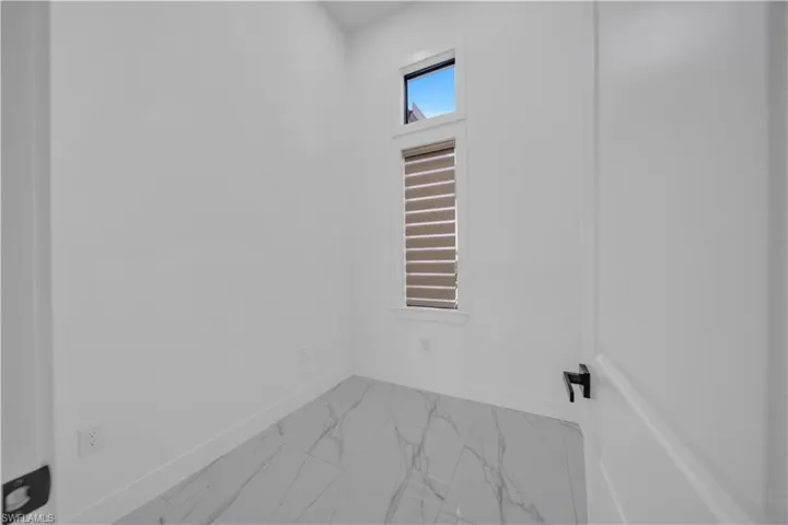 Unfurnished room with marble finish flooring and baseboards