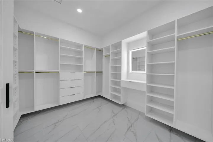 Spacious closet featuring light marble finish flooring