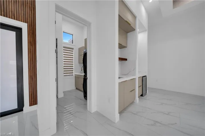 Hallway featuring light marble finish floors and beverage cooler