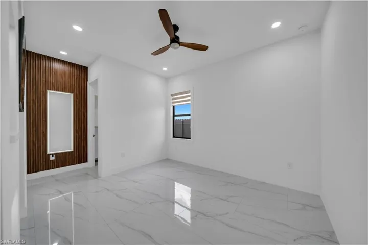 Empty room featuring light marble finish floors, recessed lighting, and a ceiling fan