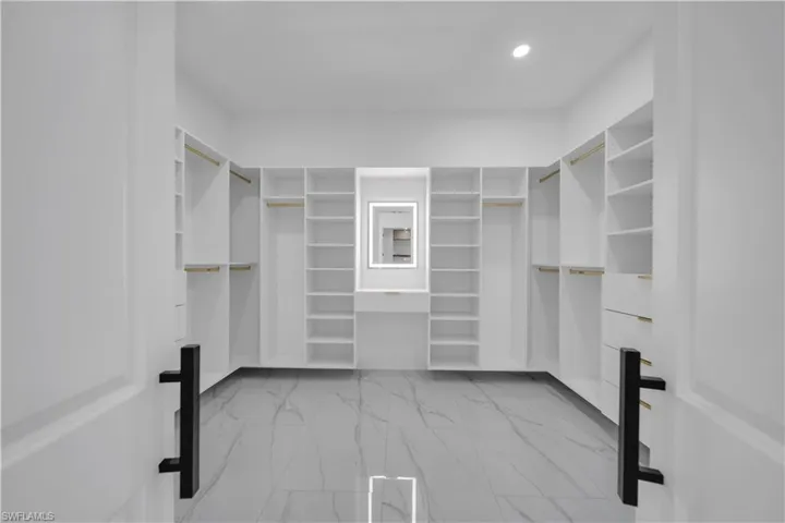 Spacious closet featuring light marble finish floors