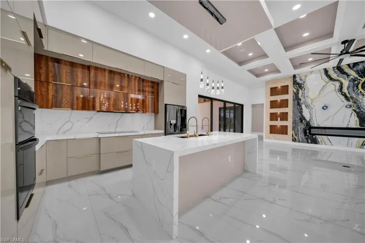 Kitchen with modern cabinets, light marble finish floors, light stone countertops, pendant lighting, and recessed lighting
