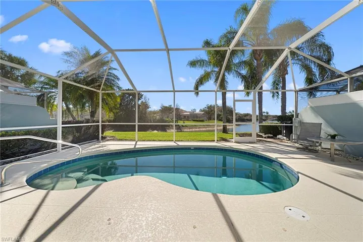 Outdoor pool featuring enclosure, a patio area, and a water view