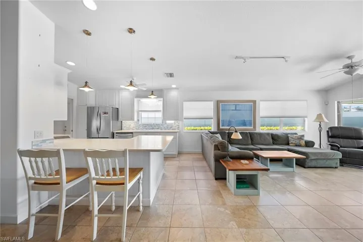 Living area with ceiling fan and light tile patterned floors