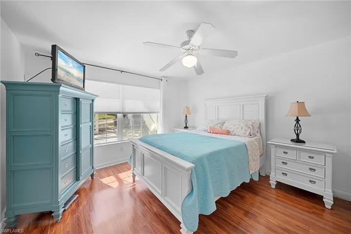 Bedroom with dark wood-style flooring and a ceiling fan