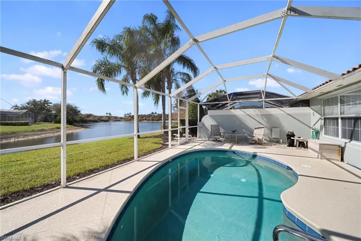 Outdoor pool featuring, a lanai, a patio, a yard, and a water view