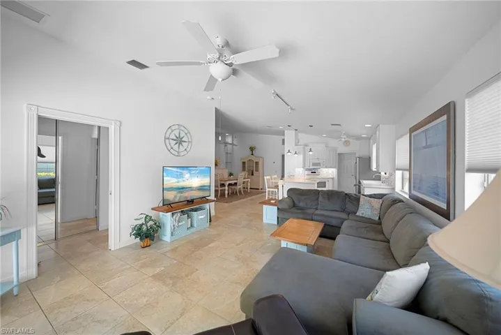 Living room featuring healthy amount of natural light, ceiling fan, and track lighting