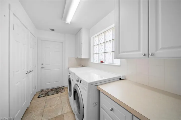 Laundry area with washer and clothes dryer and cabinet space