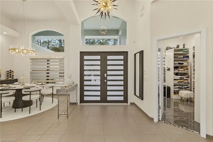 Entryway with a high ceiling, french doors, an inviting chandelier, and tile patterned floors