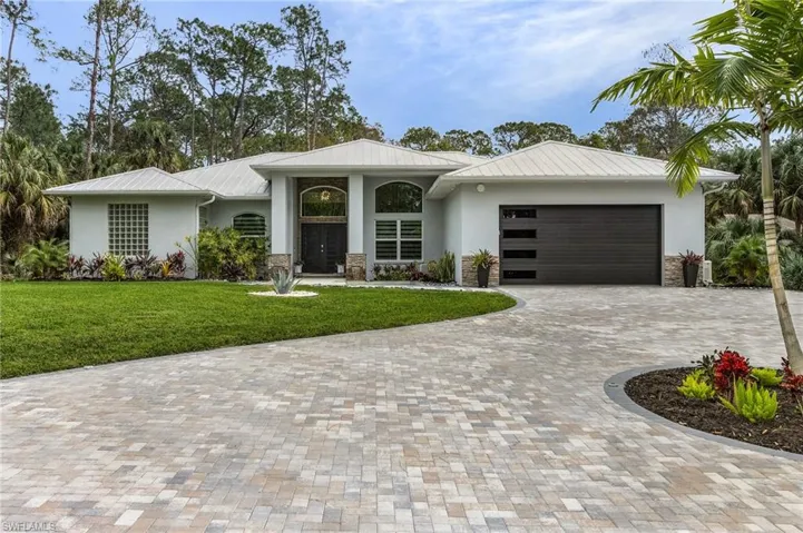 View of front of the house with front lawn, new circular driveway, and lush vegetation