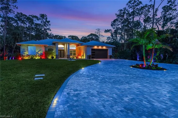View of front of property with a garage and a lawn