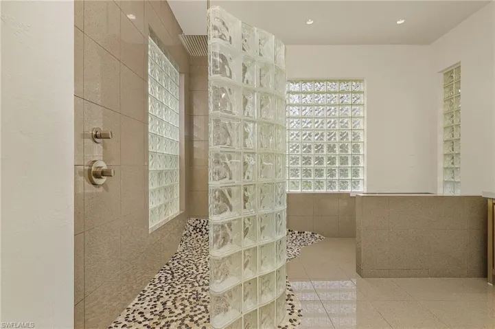 Spa-inspired shower featuring a river stone pebble tile floor. rain-shower and hand-held shower as well.