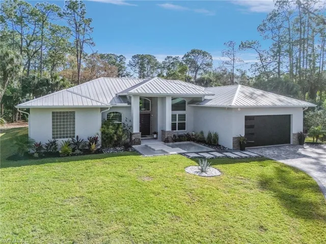 View of front of house with a garage and a front yard