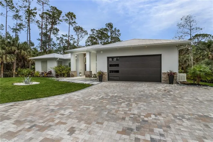 View of front of property with a front lawn and a garage