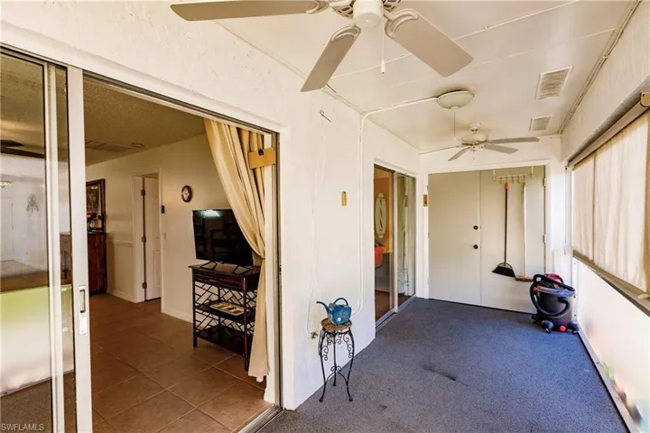 Versatile multipurpose room with ceiling fans, large windows providing natural light, and direct access to adjacent spaces