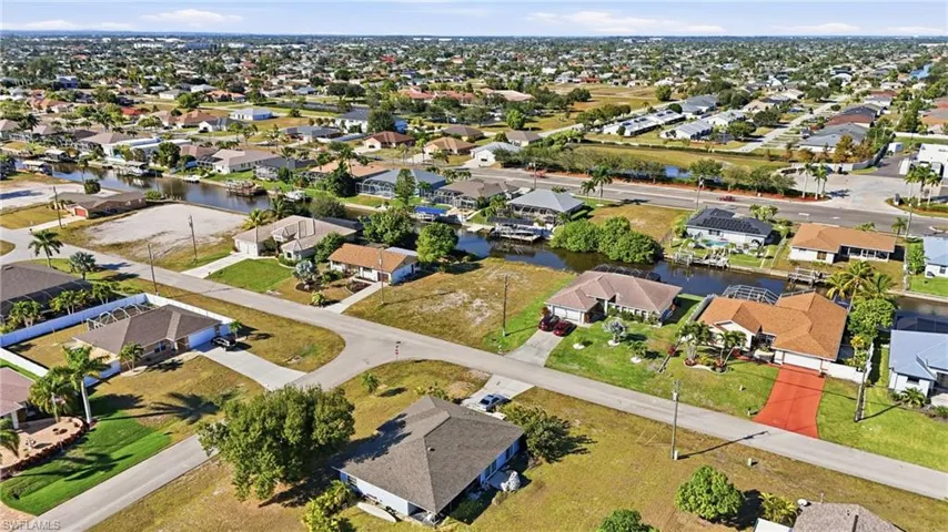 Aerial view of property and surrounding area with nearby suburban area and a nearby body of water